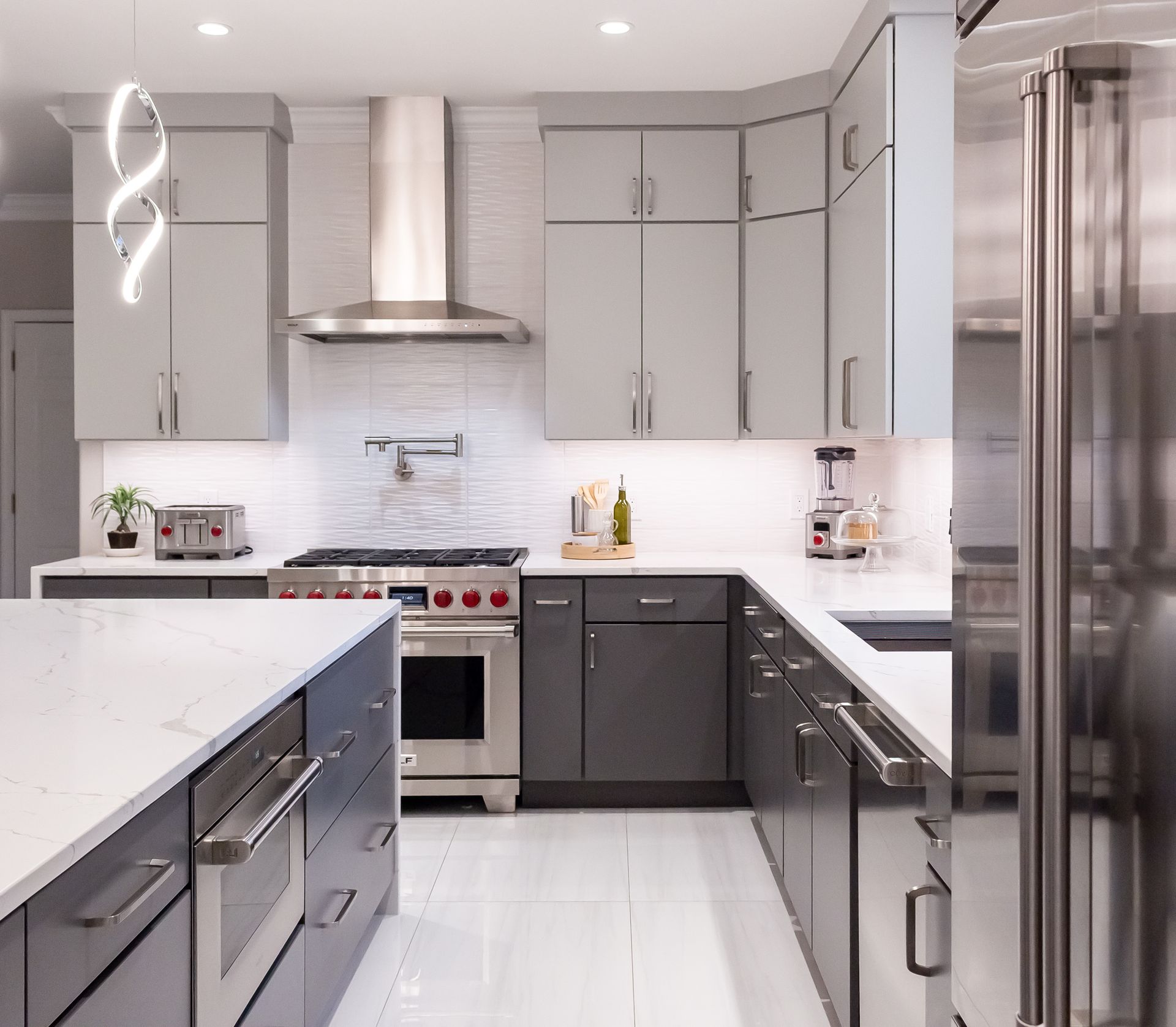 A kitchen with gray cabinets and stainless steel appliances