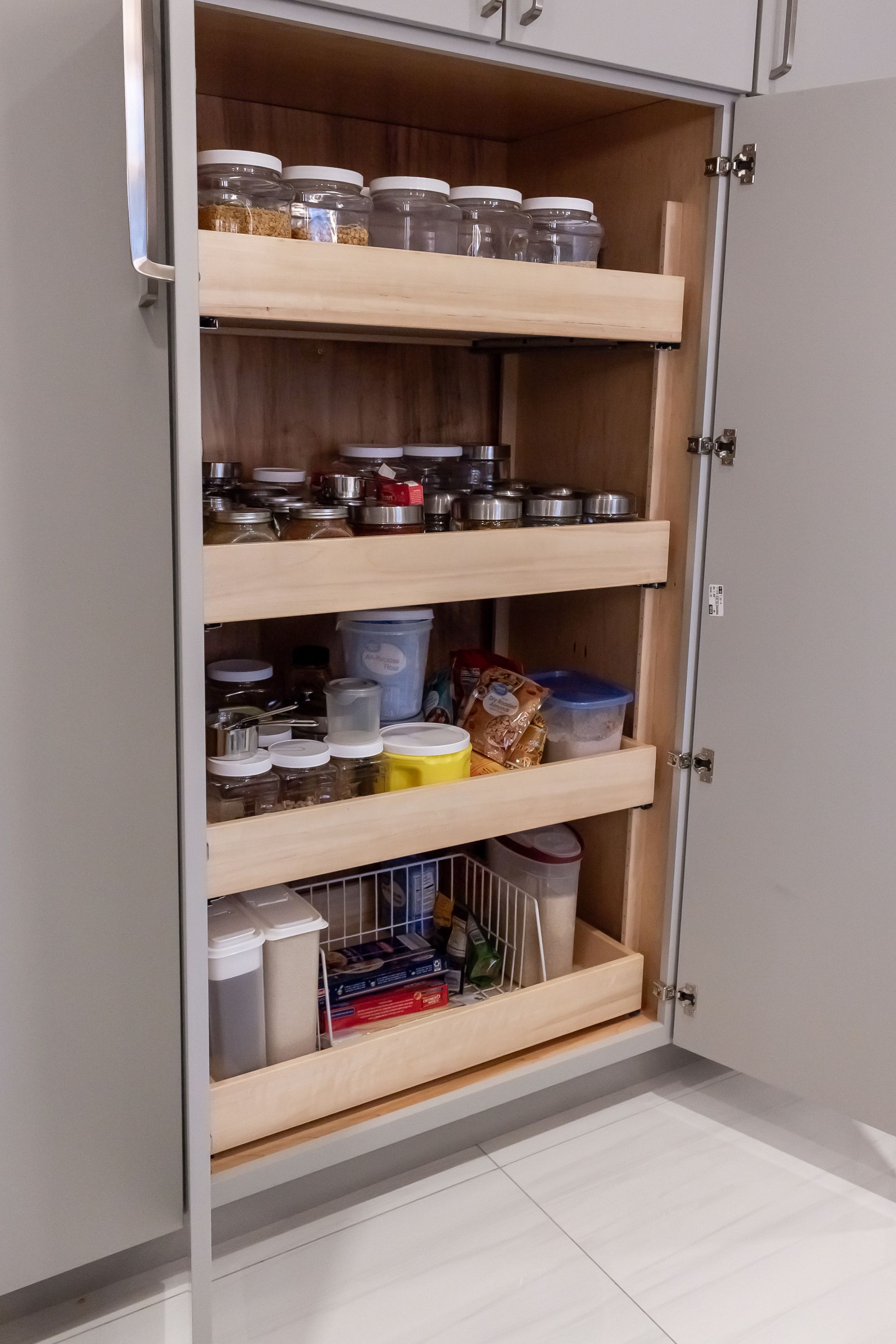 A pantry in a kitchen with a lot of food in it.