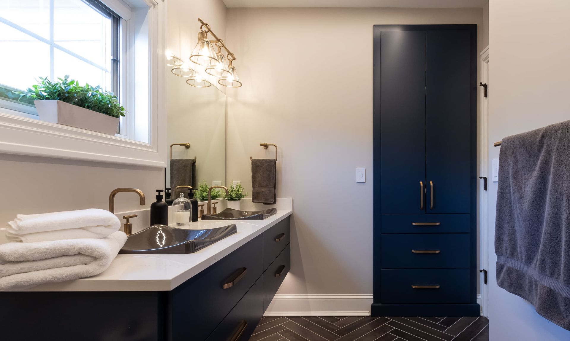 A bathroom with a sink , mirror , cabinets and towels.