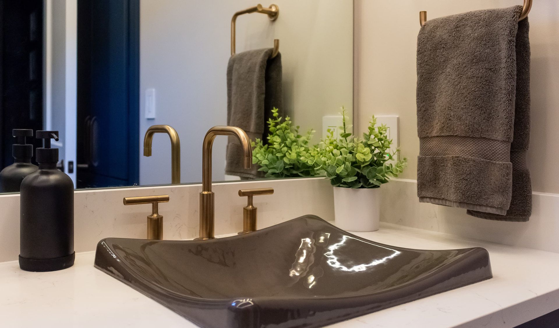A bathroom sink with a mirror and towels on the counter.