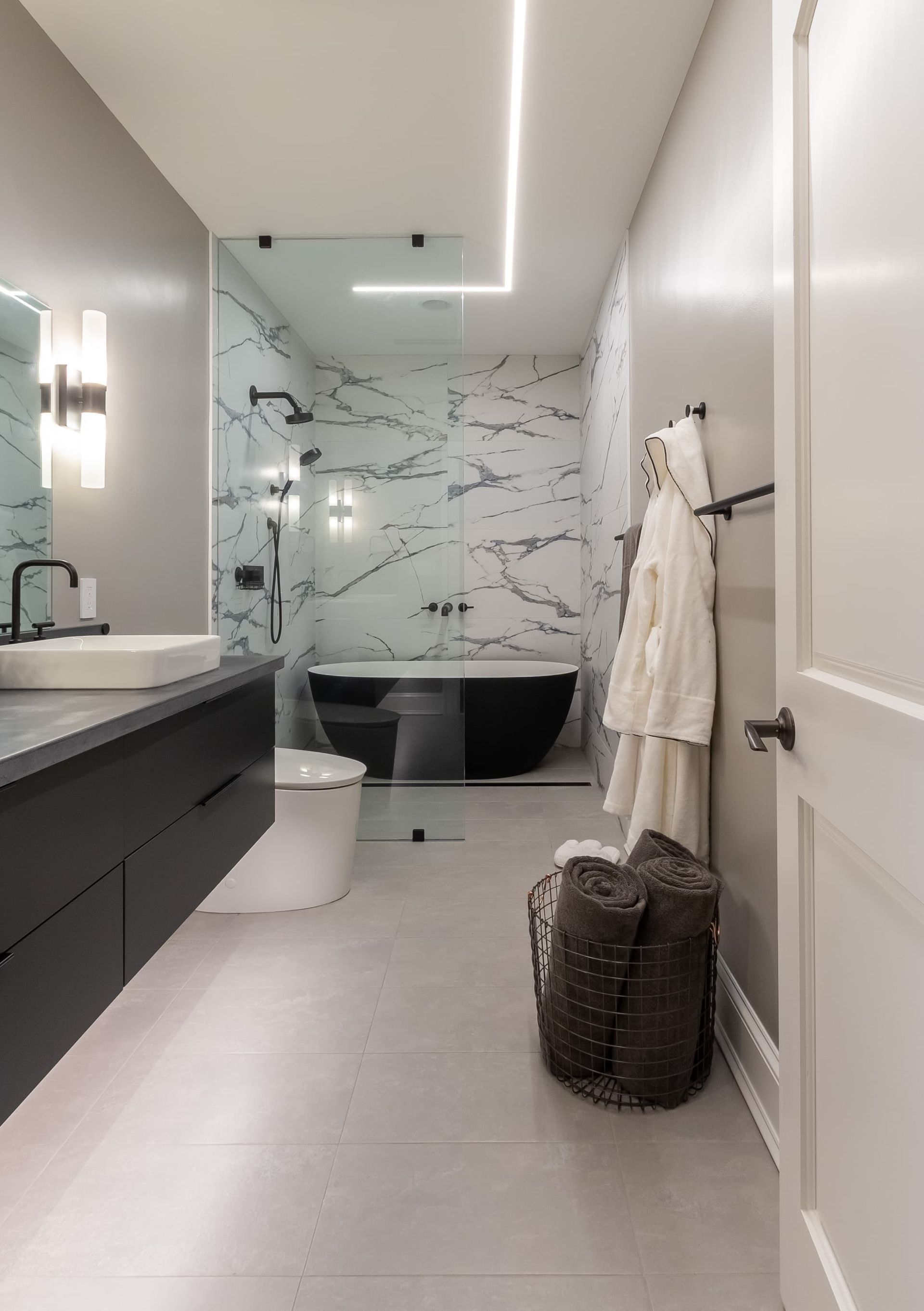 A bathroom with a tub , sink , toilet and mirror.