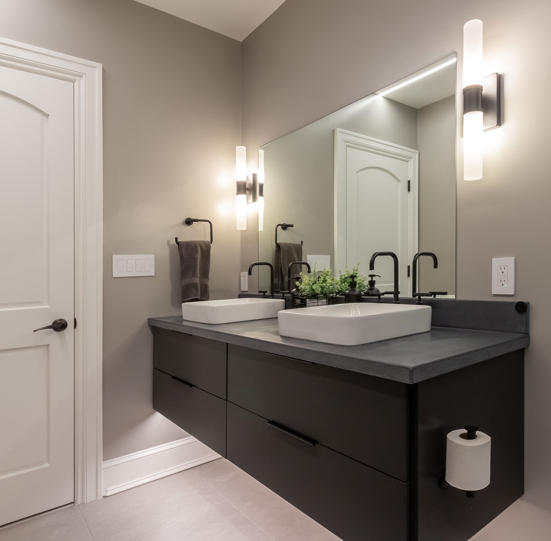A bathroom with two sinks and a large mirror