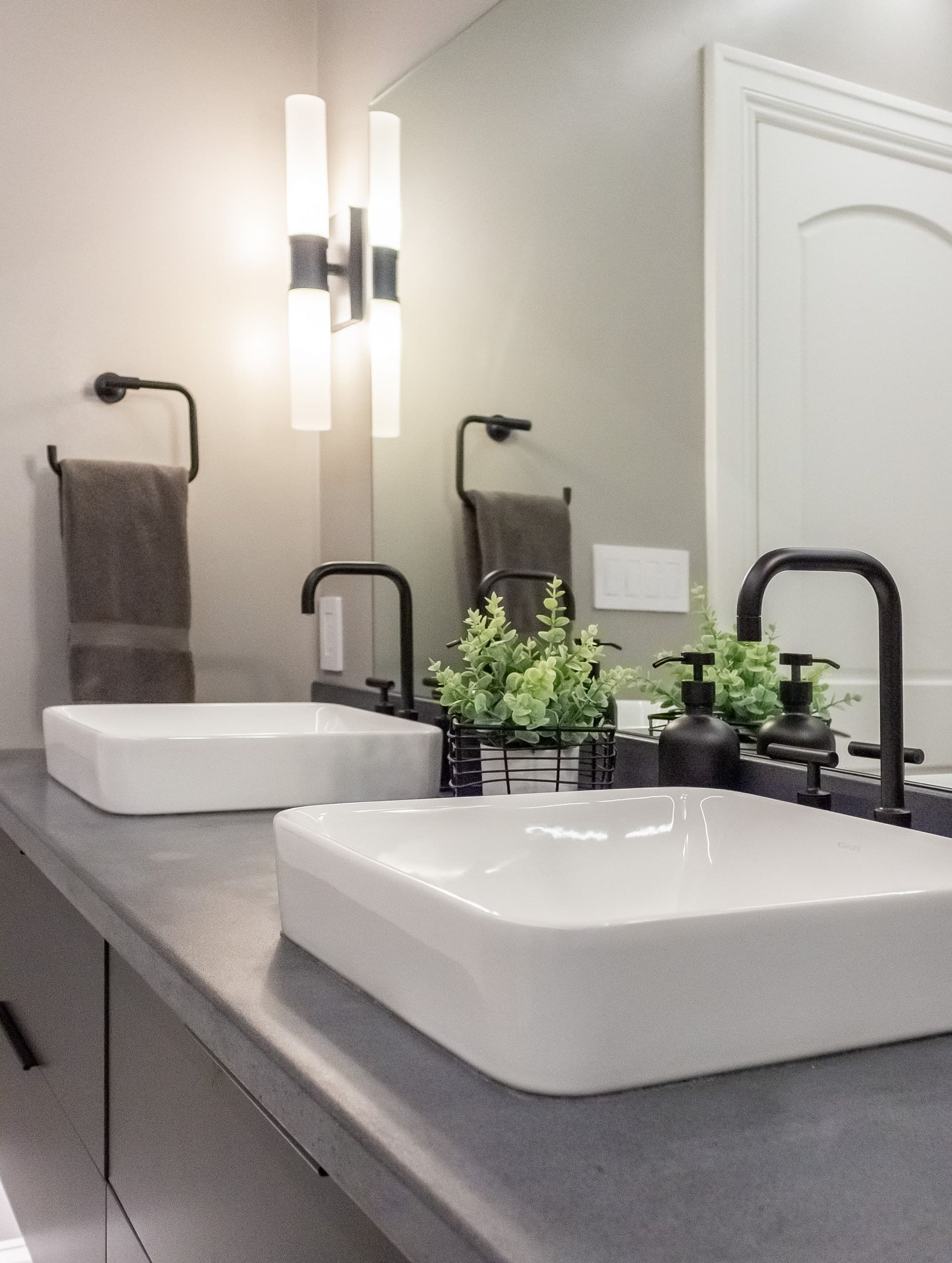 A bathroom with two sinks and a mirror.