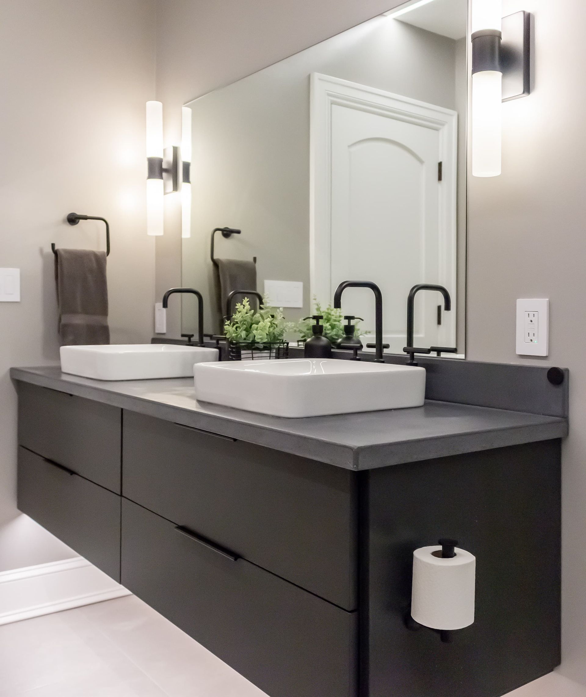 A bathroom with two sinks and a large mirror
