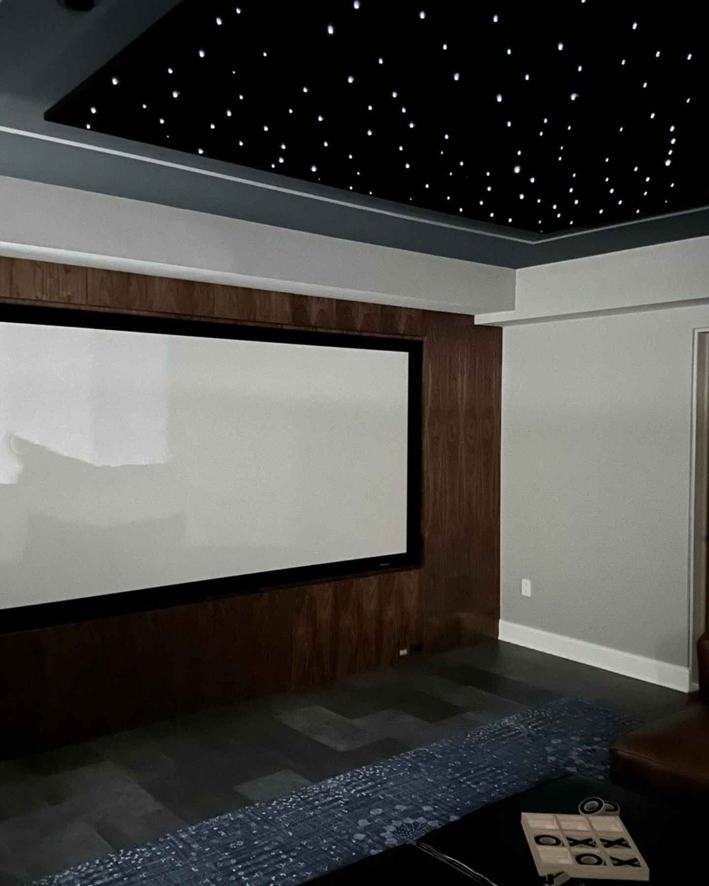 A room with a projector screen and a ceiling with stars