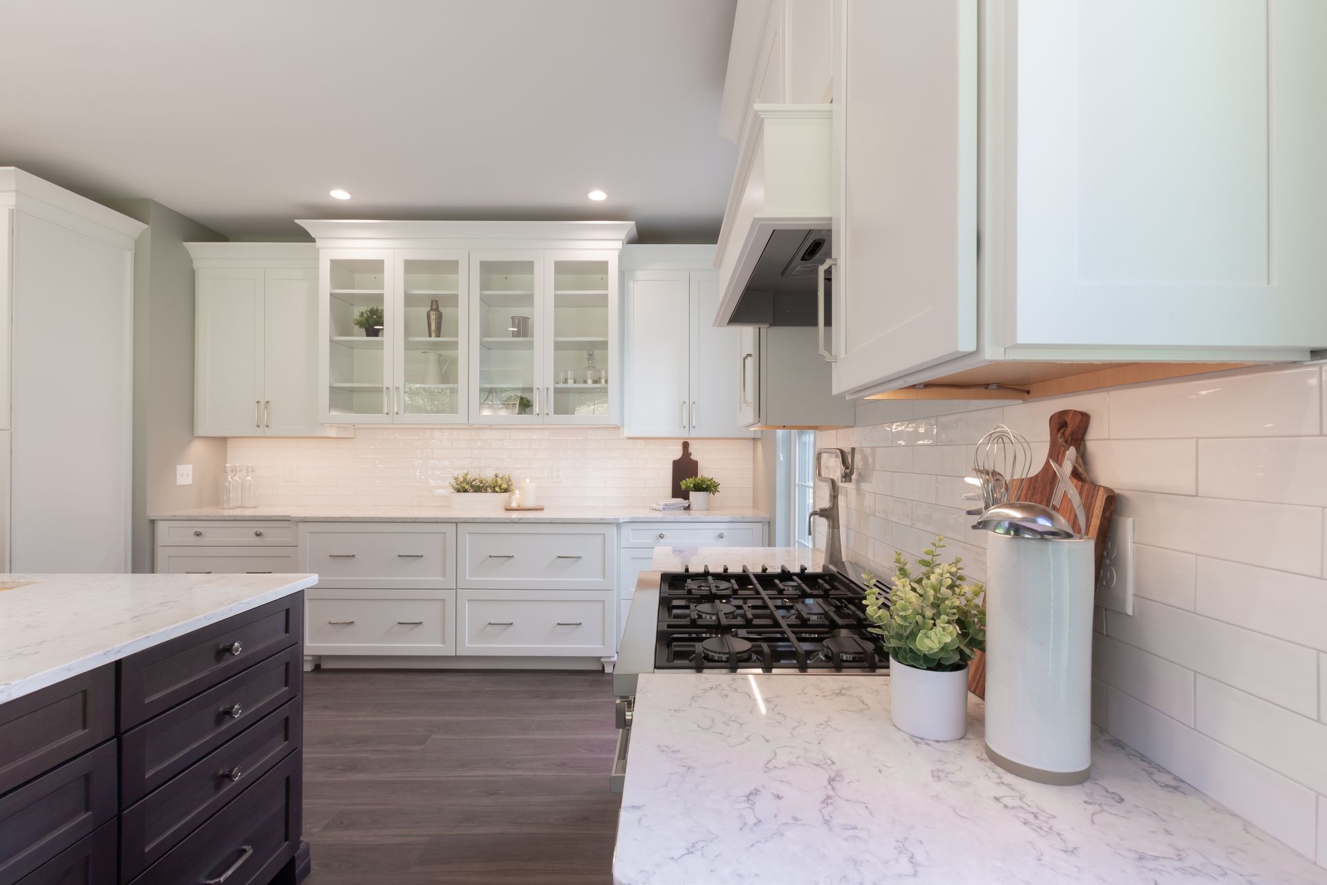 A kitchen with white cabinets and a stove top oven.