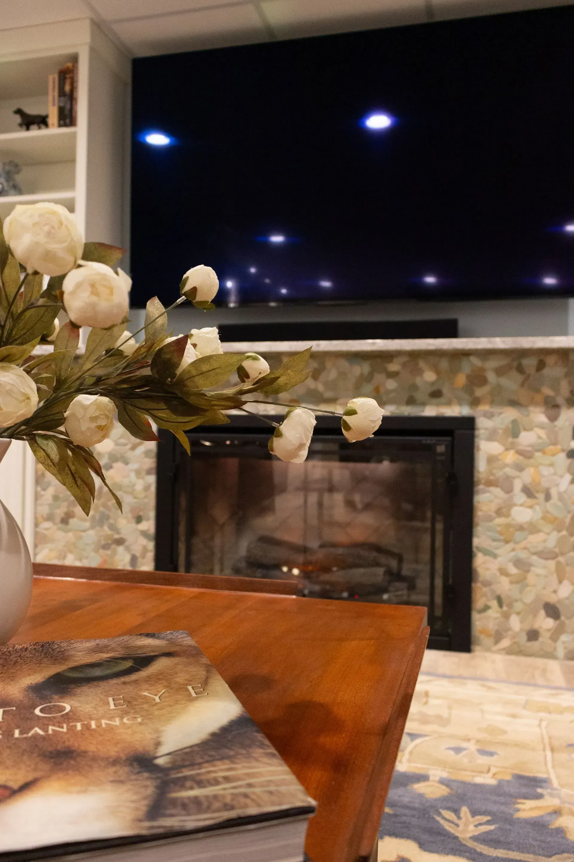 A living room with a fireplace and a flat screen tv.