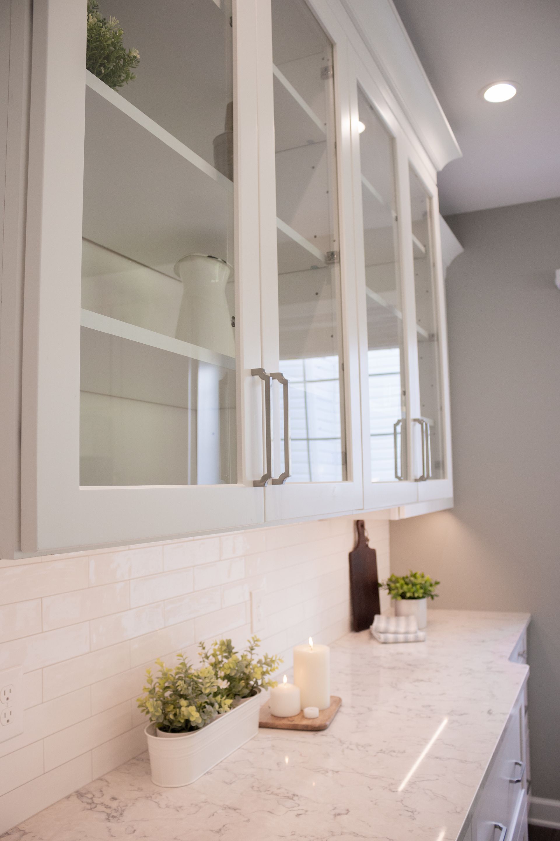 A kitchen with white cabinets and a candle on the counter.