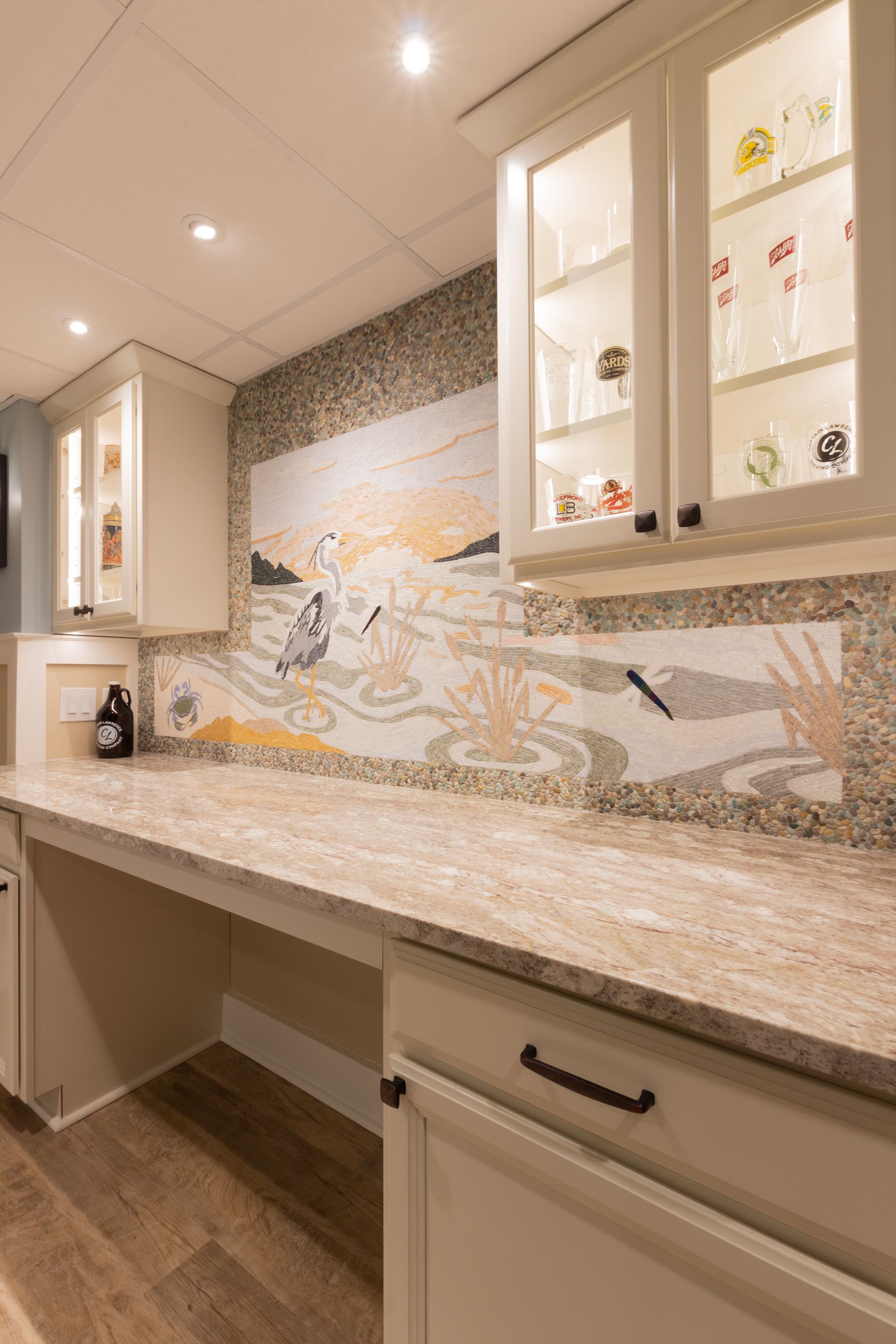 There is a painting on the wall above the counter in the kitchen.