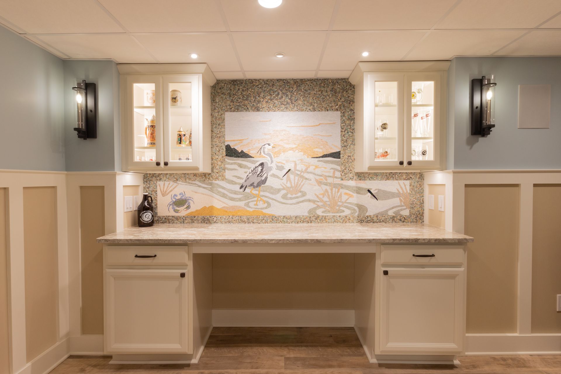 A basement with a desk and cabinets and a painting on the wall.