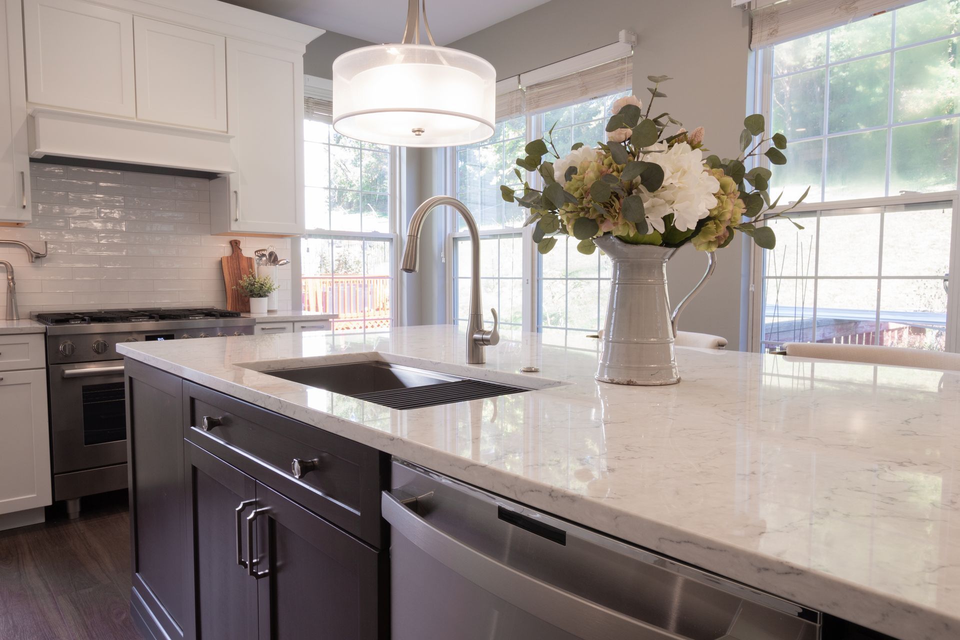 A kitchen with a sink and a vase of flowers on the counter.