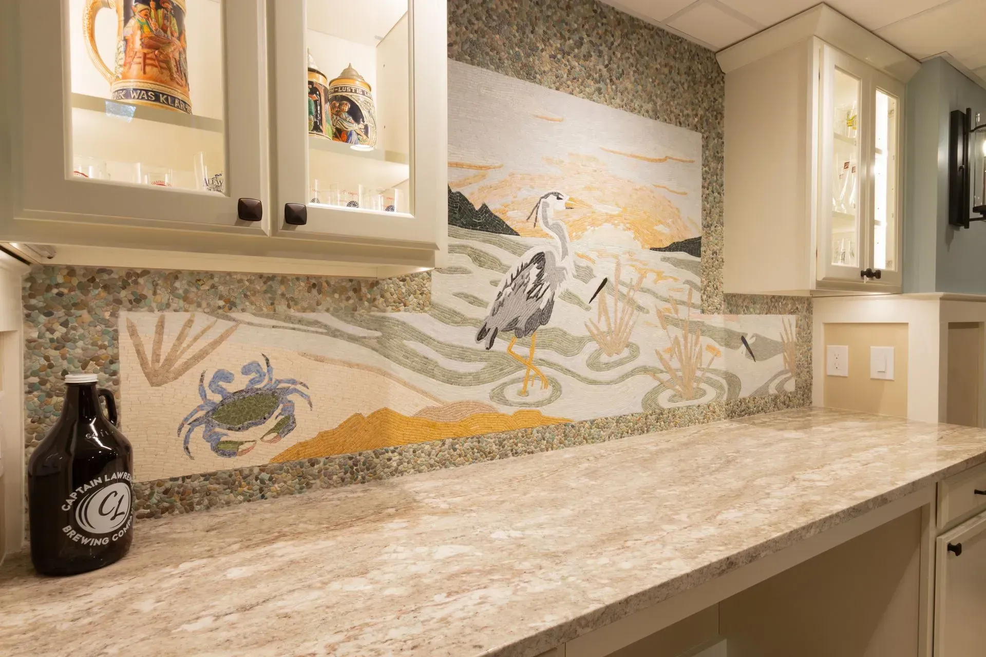 A kitchen with a mural on the wall and a bottle of beer on the counter.