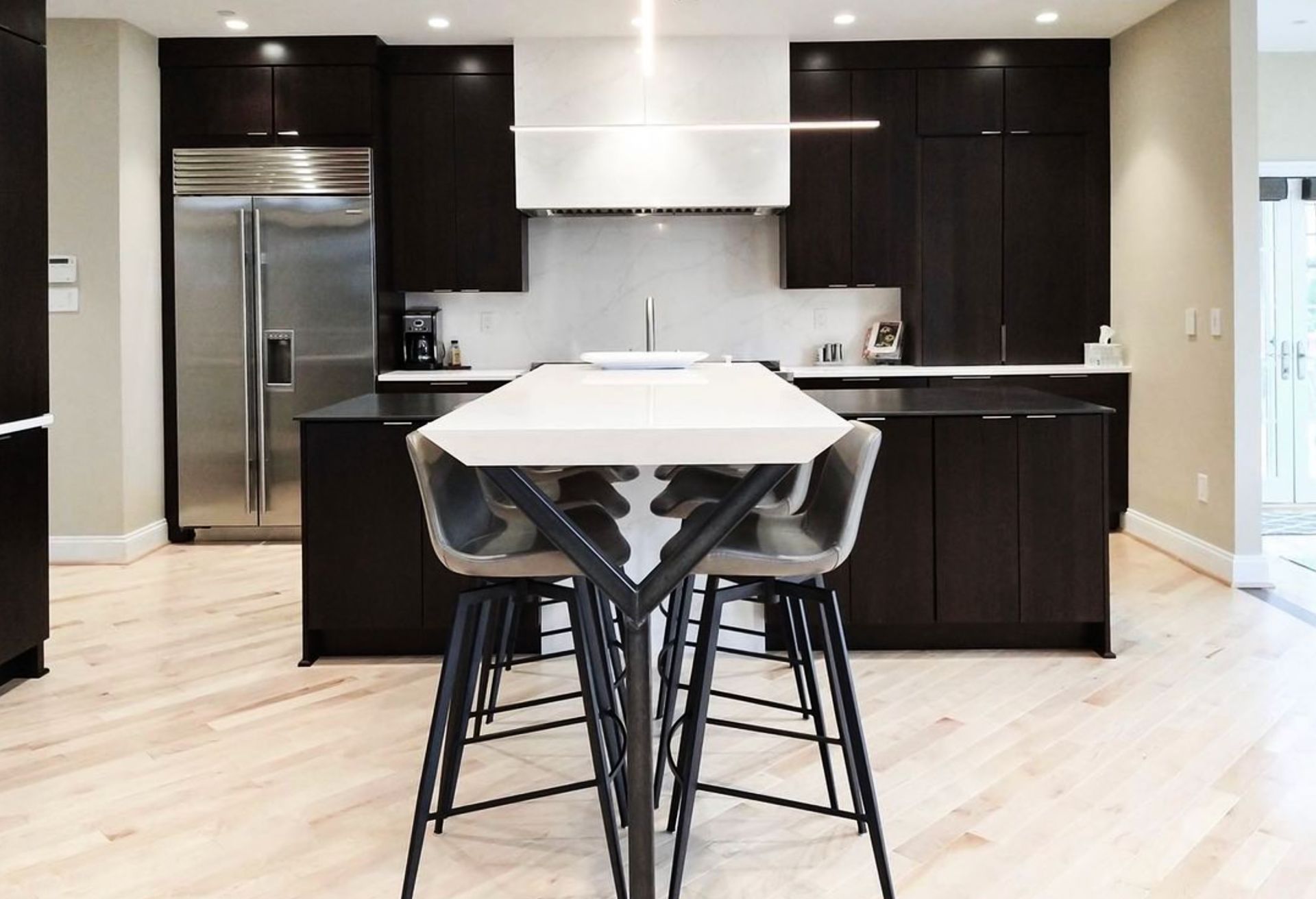 A kitchen with a table and stools in it