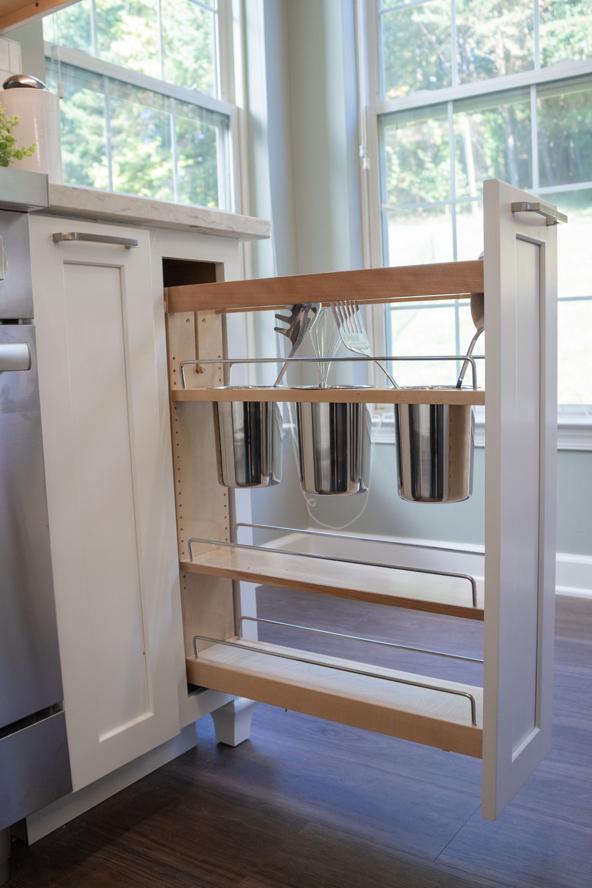 A kitchen with a pull out drawer filled with pots and pans.