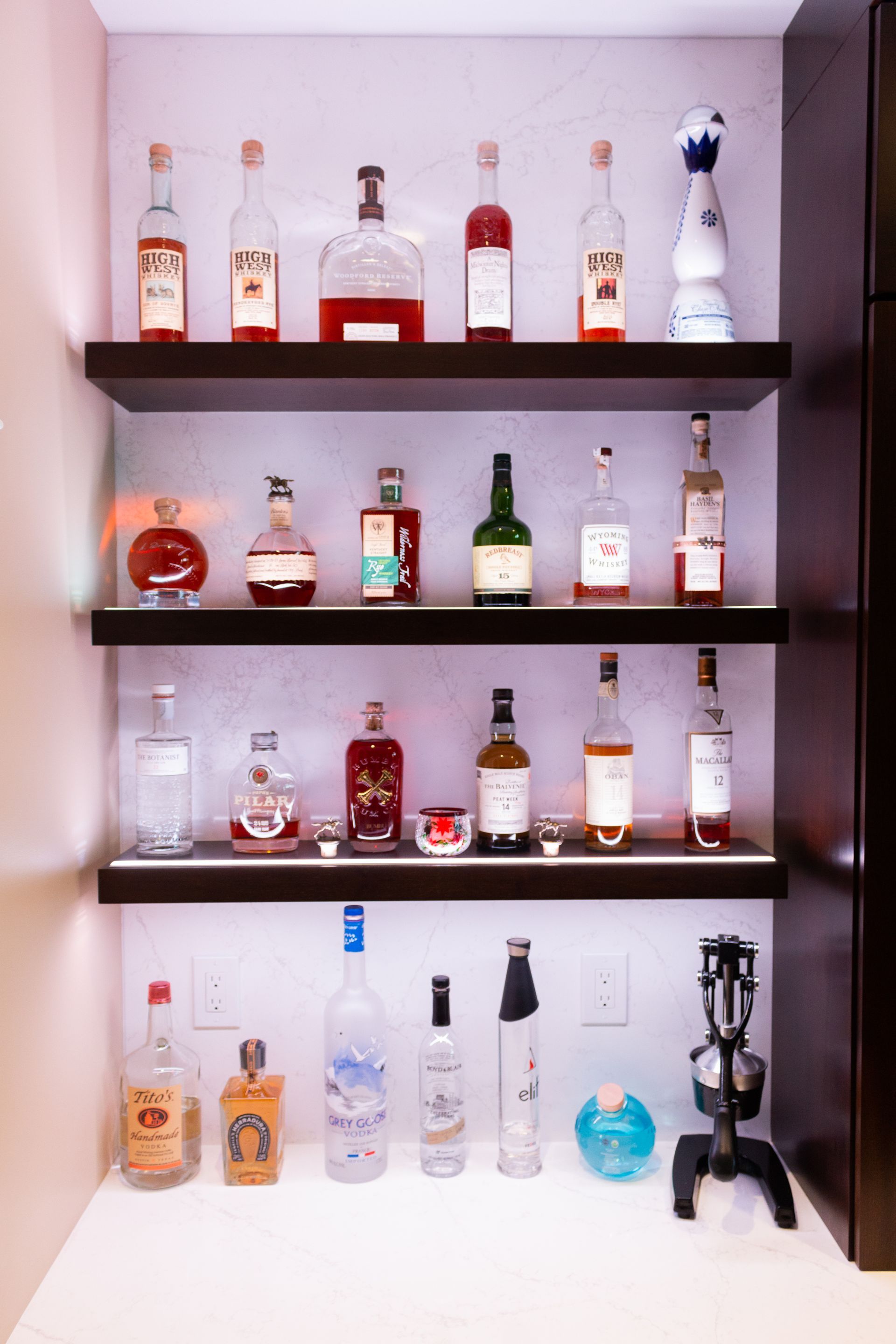 A shelf filled with lots of bottles of alcohol