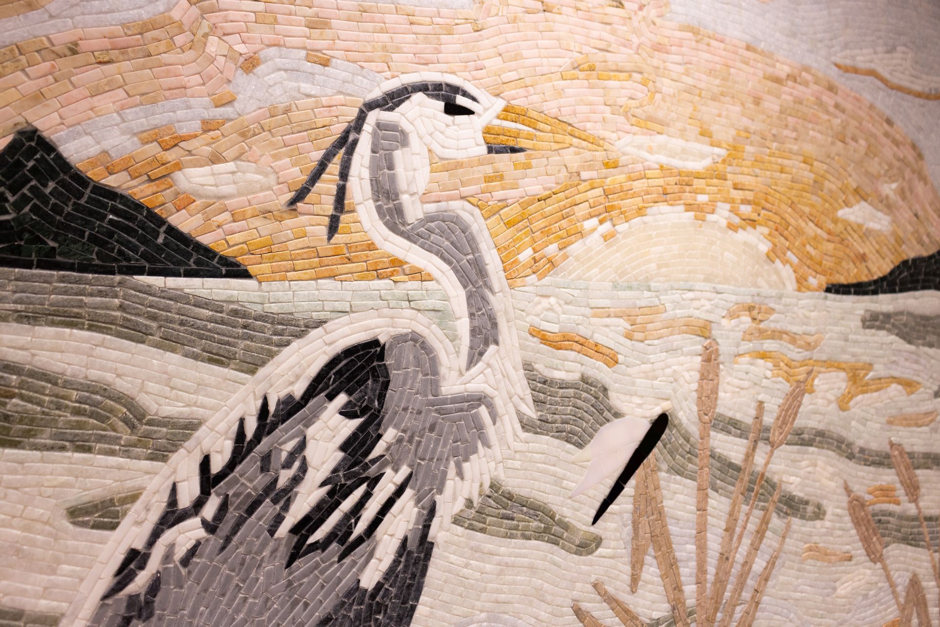 A mosaic of a bird standing next to a body of water.