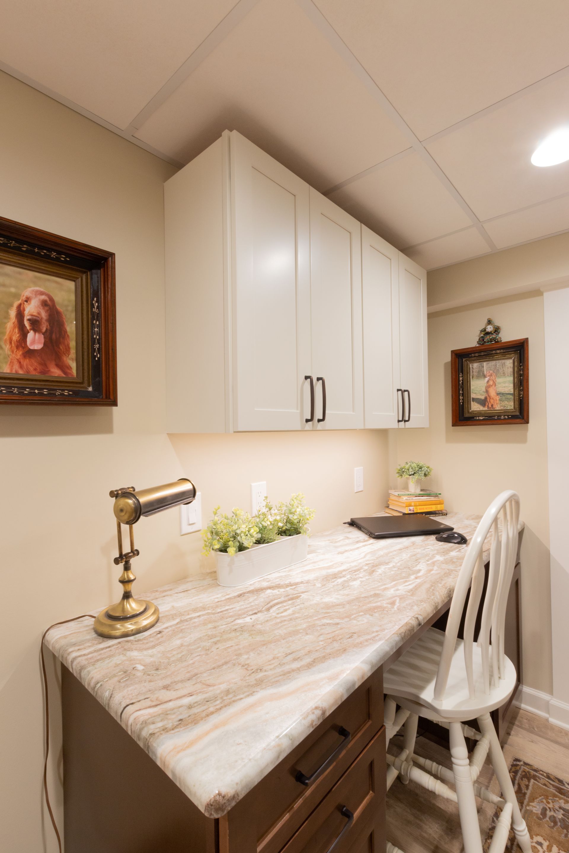 There is a picture of a dog on the wall above the desk.
