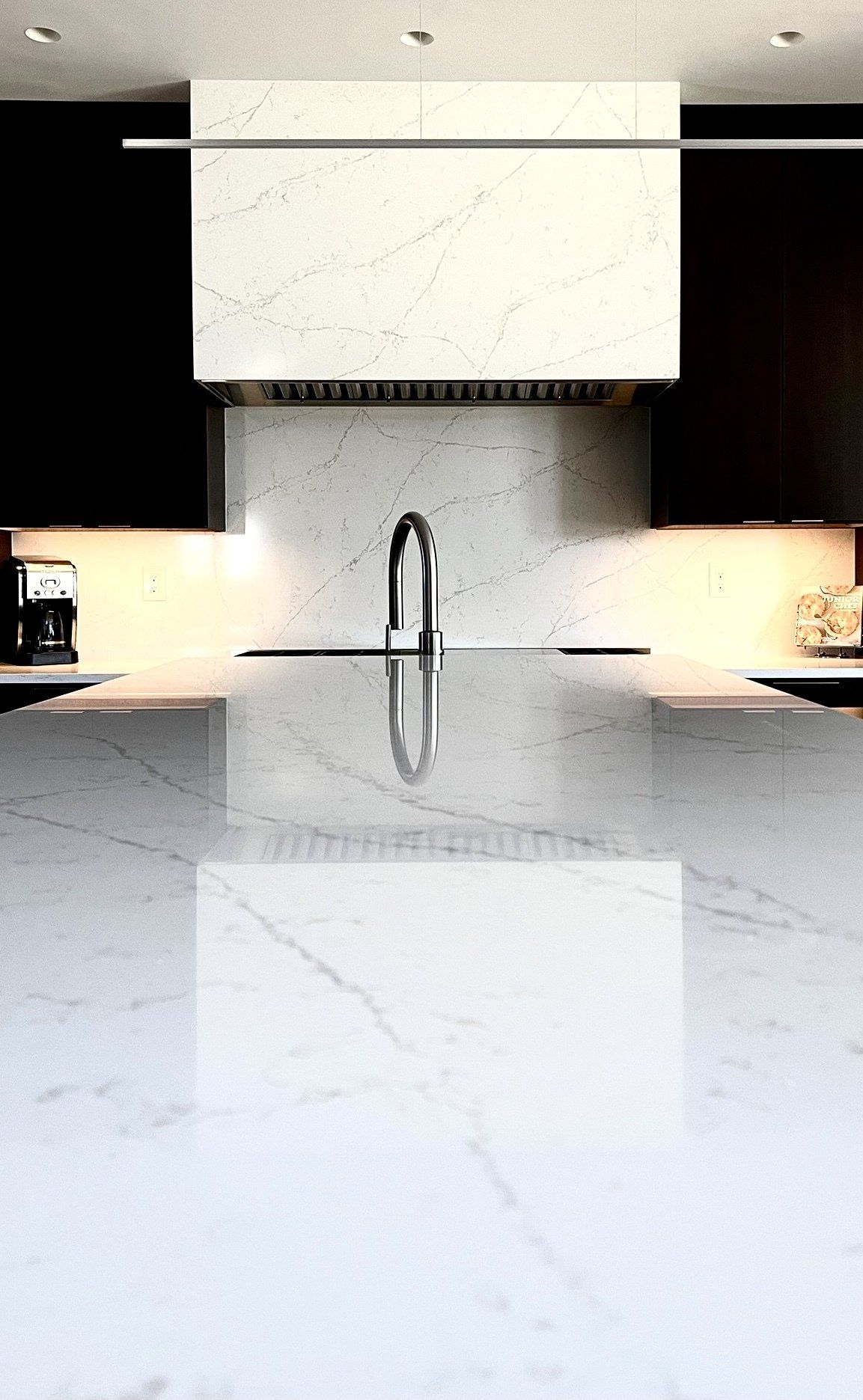A kitchen with a marble counter top and a sink