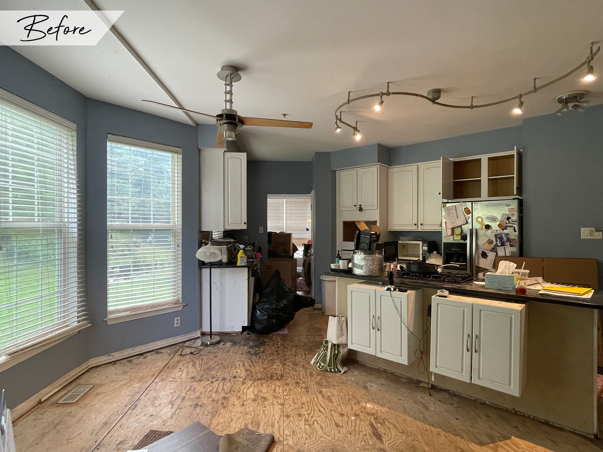A before picture of a kitchen with white cabinets and a ceiling fan.