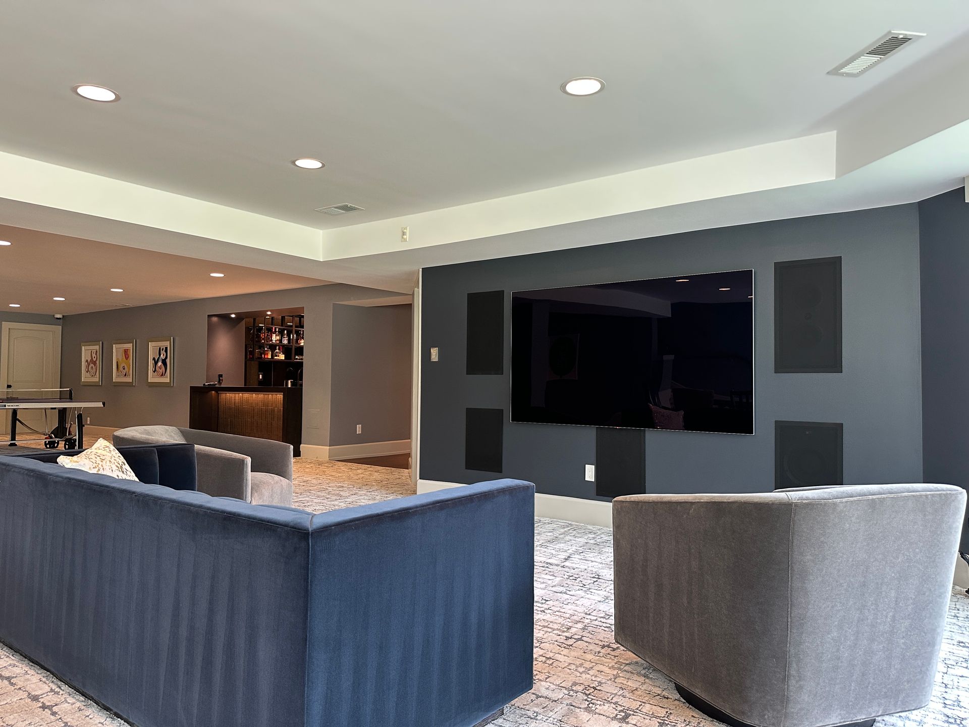 A living room with a couch , chairs and a flat screen tv.