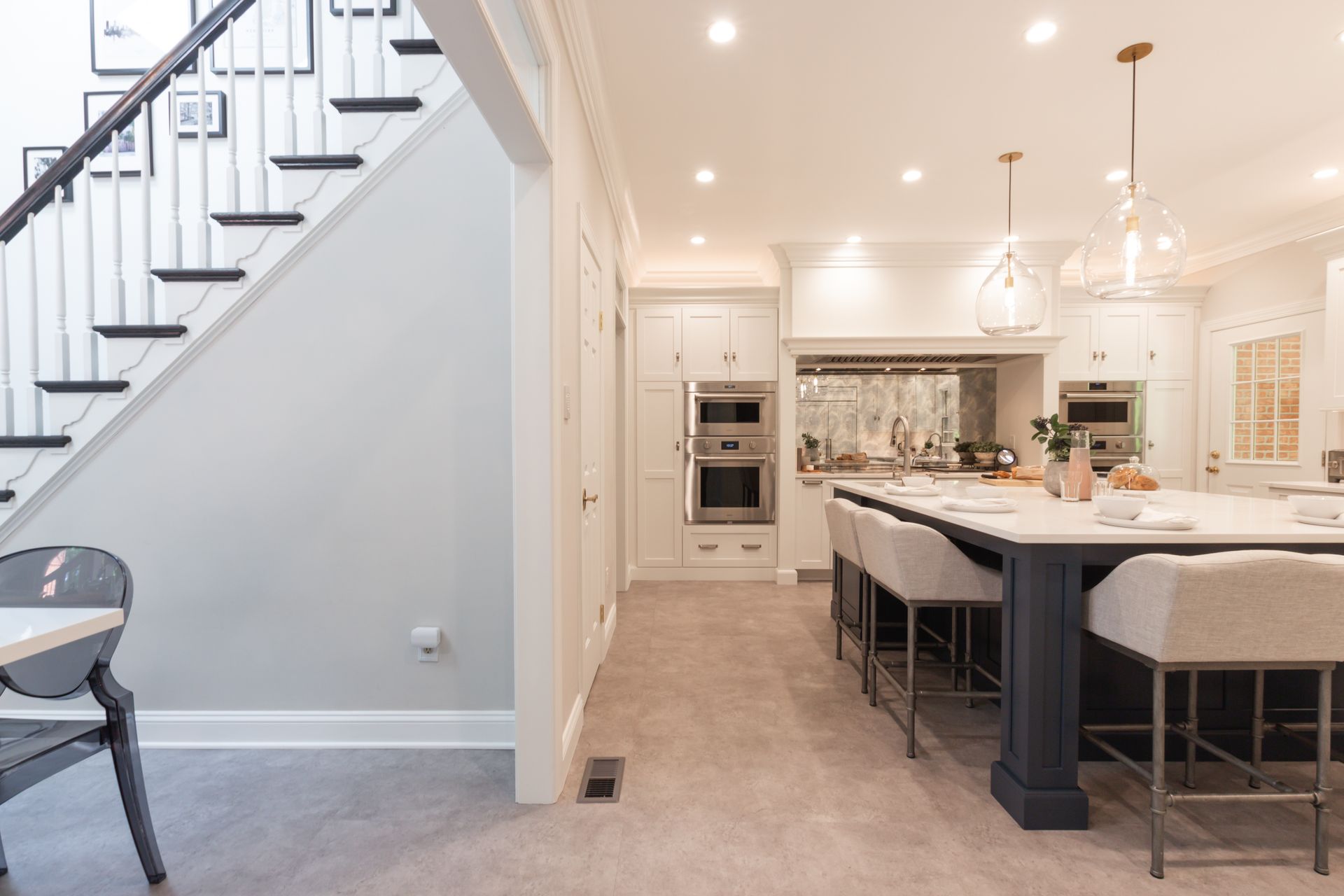 A kitchen with a large island and stairs leading up to the second floor