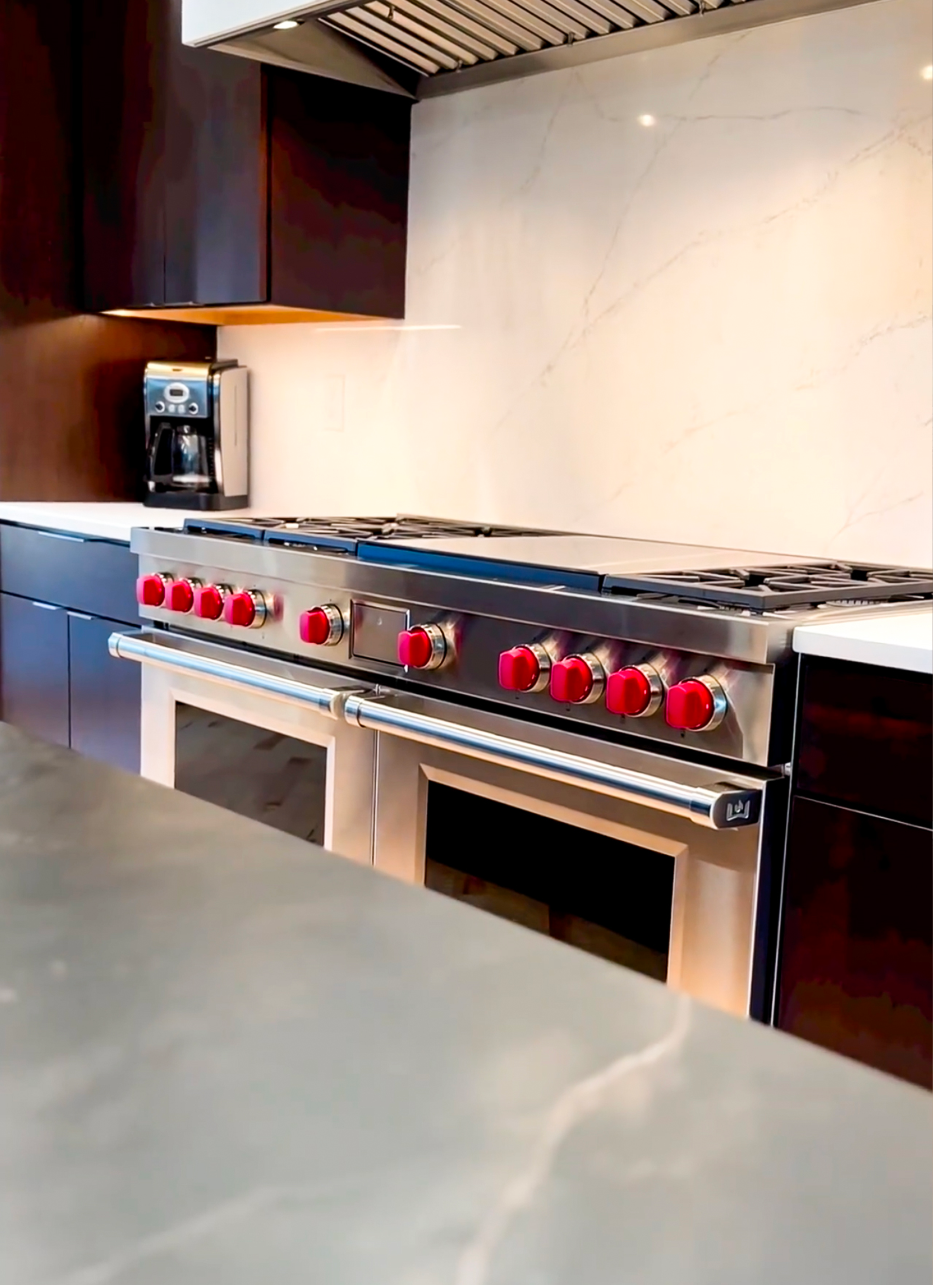 A kitchen with a stove top oven with red knobs
