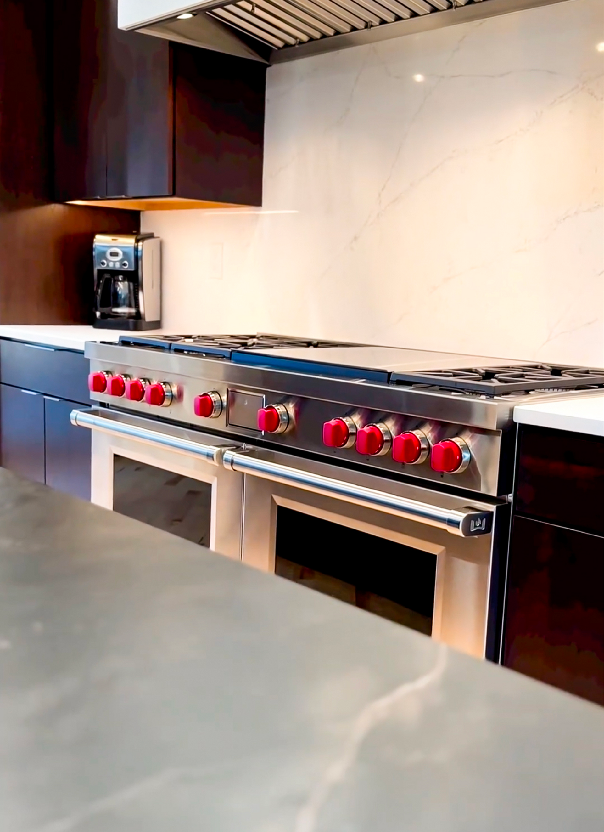A kitchen with a stove top oven and a coffee maker
