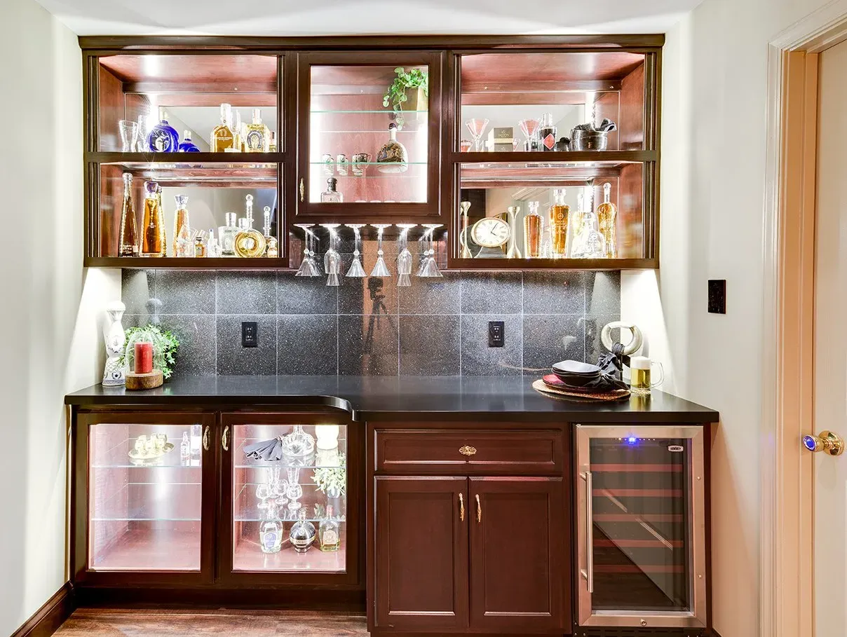 A kitchen with a bar and a wine cooler