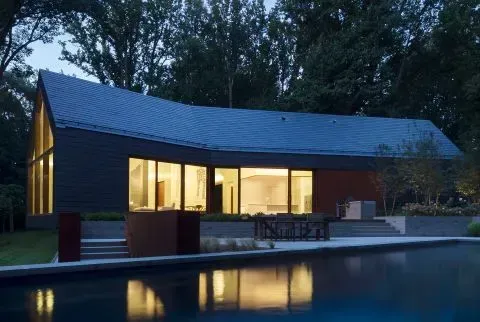 A house with a swimming pool in front of it
