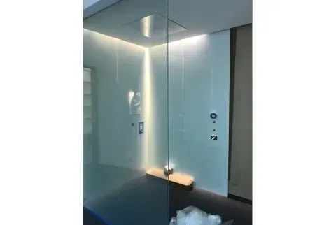 A room with a glass wall and a light on the wall.