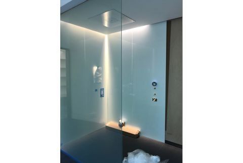 A bathroom with a glass shower door and a bathtub.