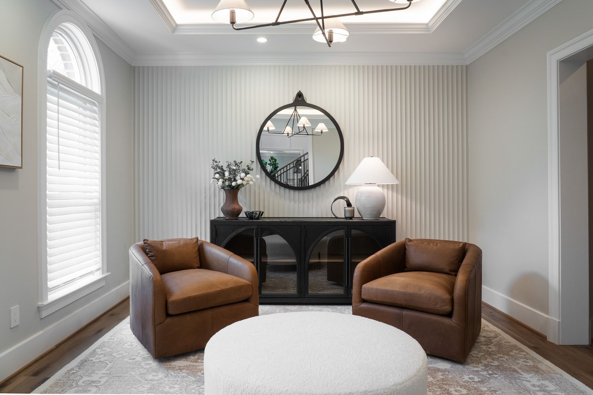 There are two chairs and an ottoman in the living room.