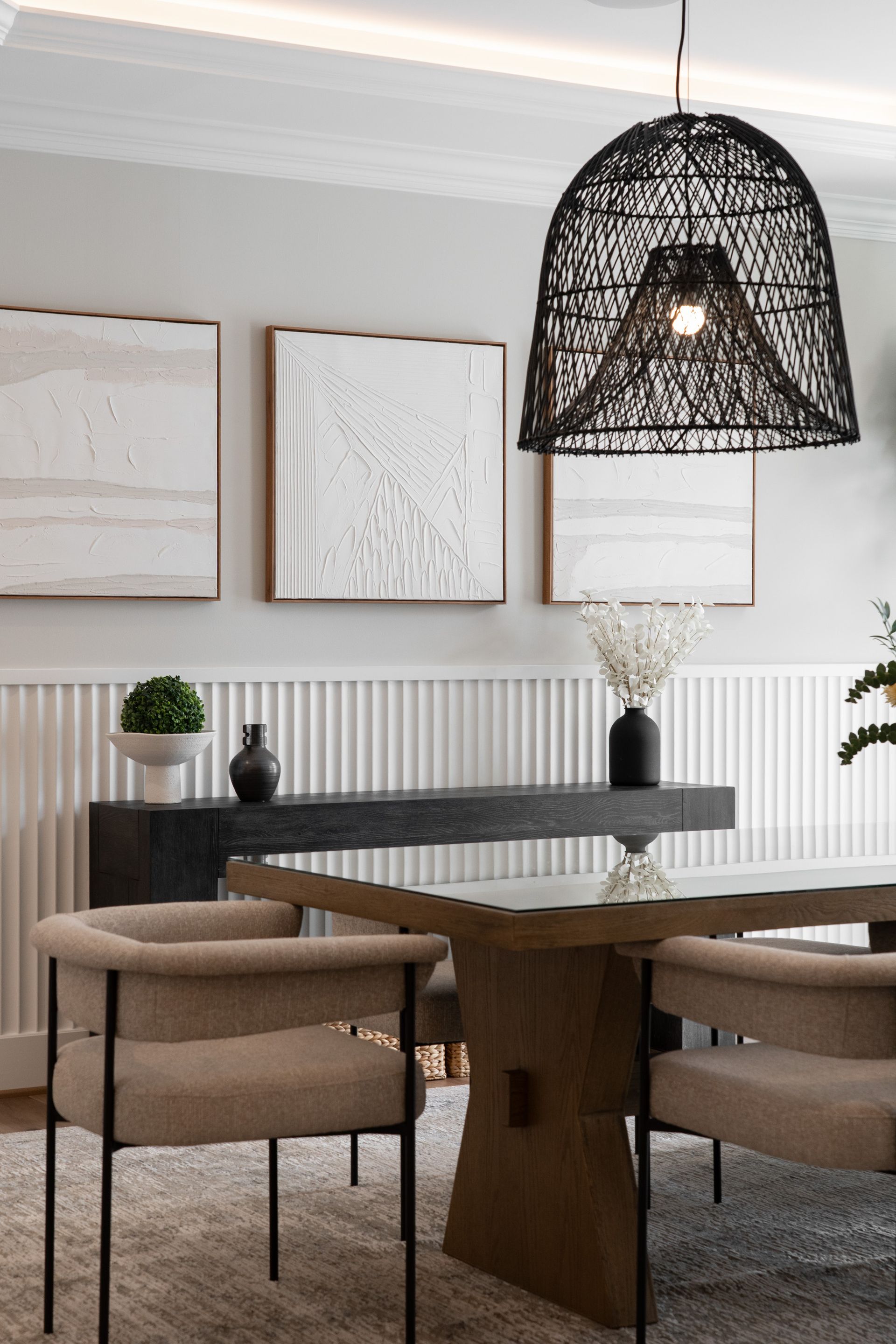 A dining room with a table and chairs and a pendant light.