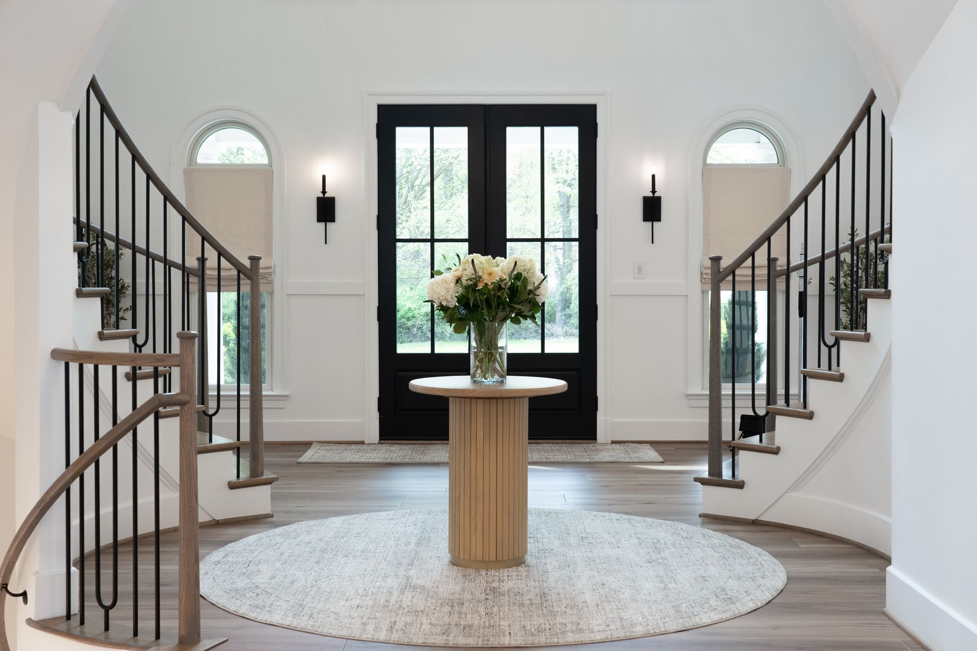 There is a table with flowers on it in the middle of the room.