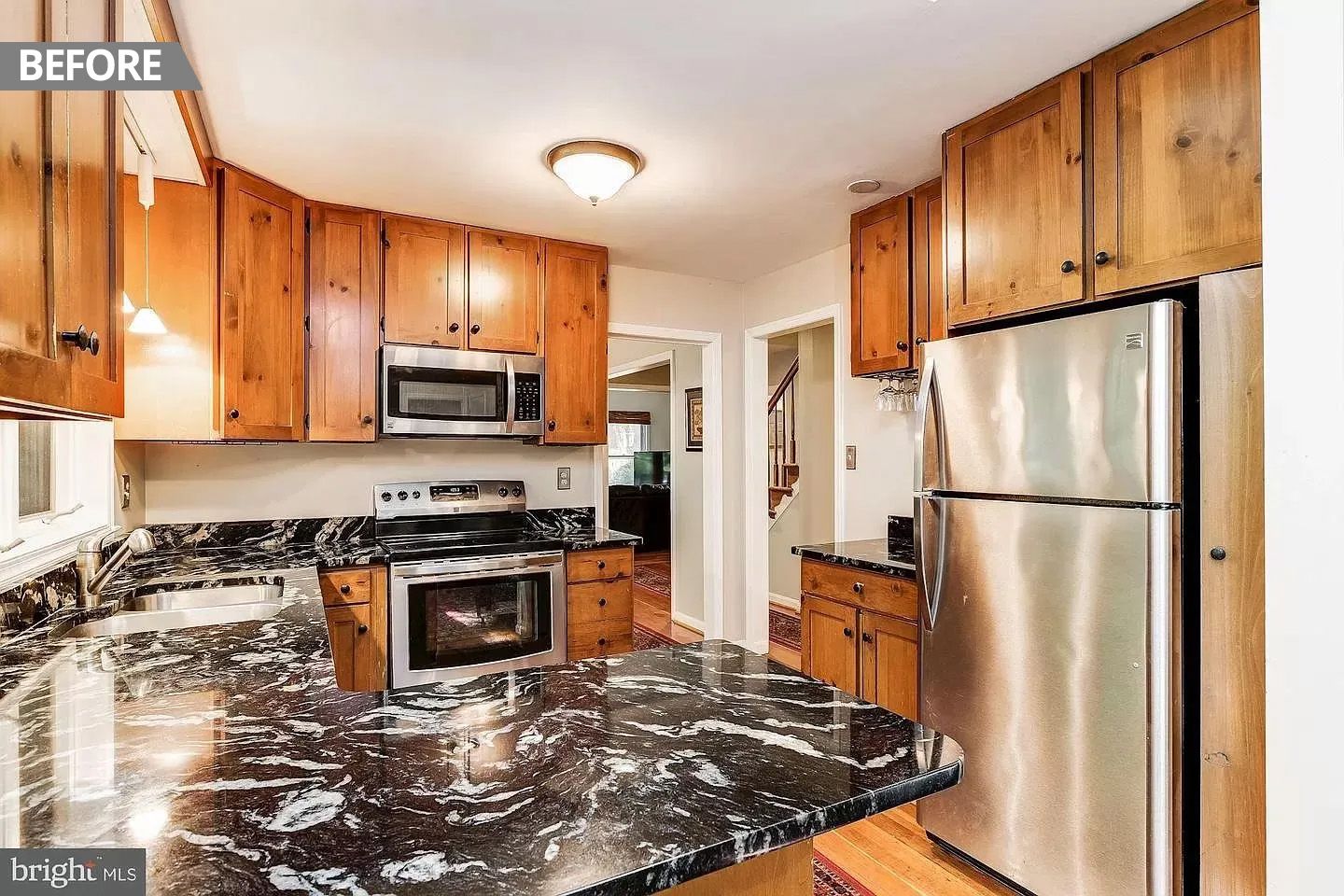 A kitchen with stainless steel appliances , granite counter tops , and wooden cabinets.