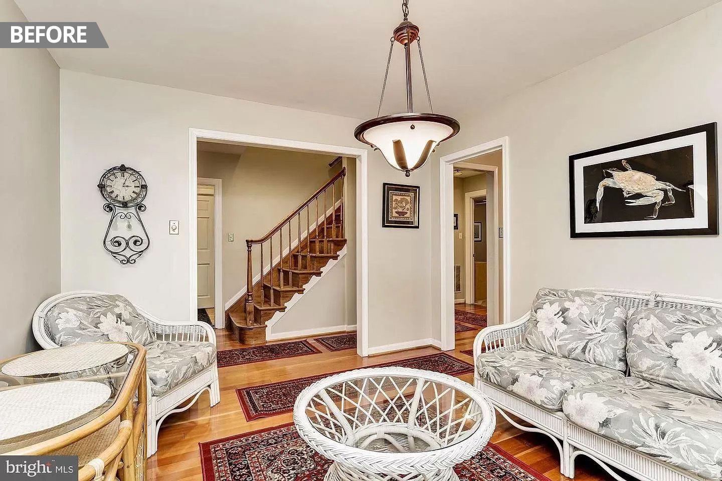 A living room with a couch , chairs , table and stairs.