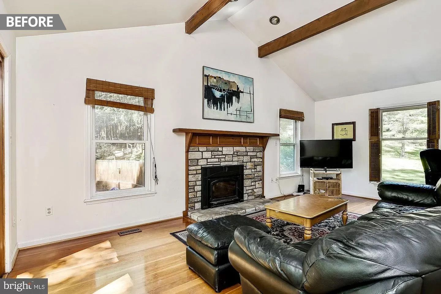 A living room with a fireplace , couch , and television.