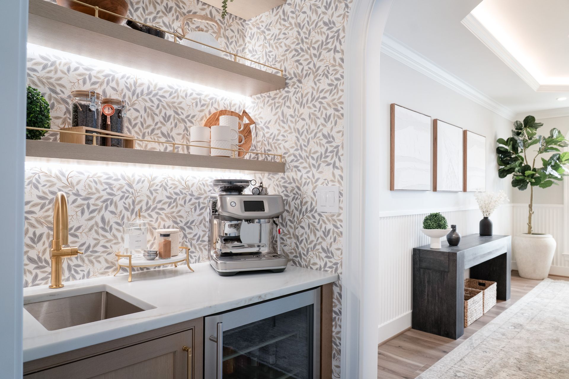 A kitchen with a sink , coffee maker , and refrigerator.