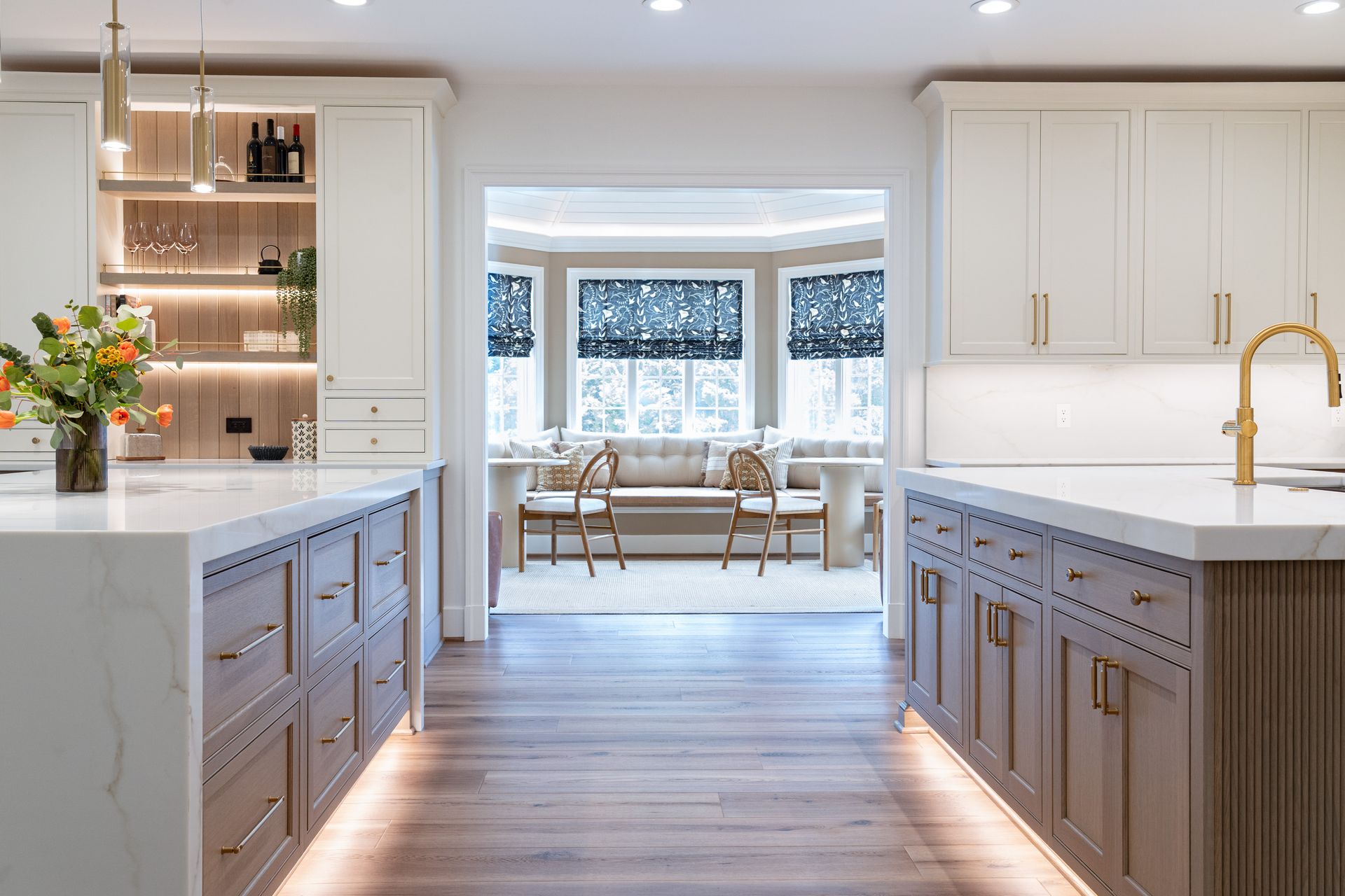 A kitchen with a large island and a living room in the background.