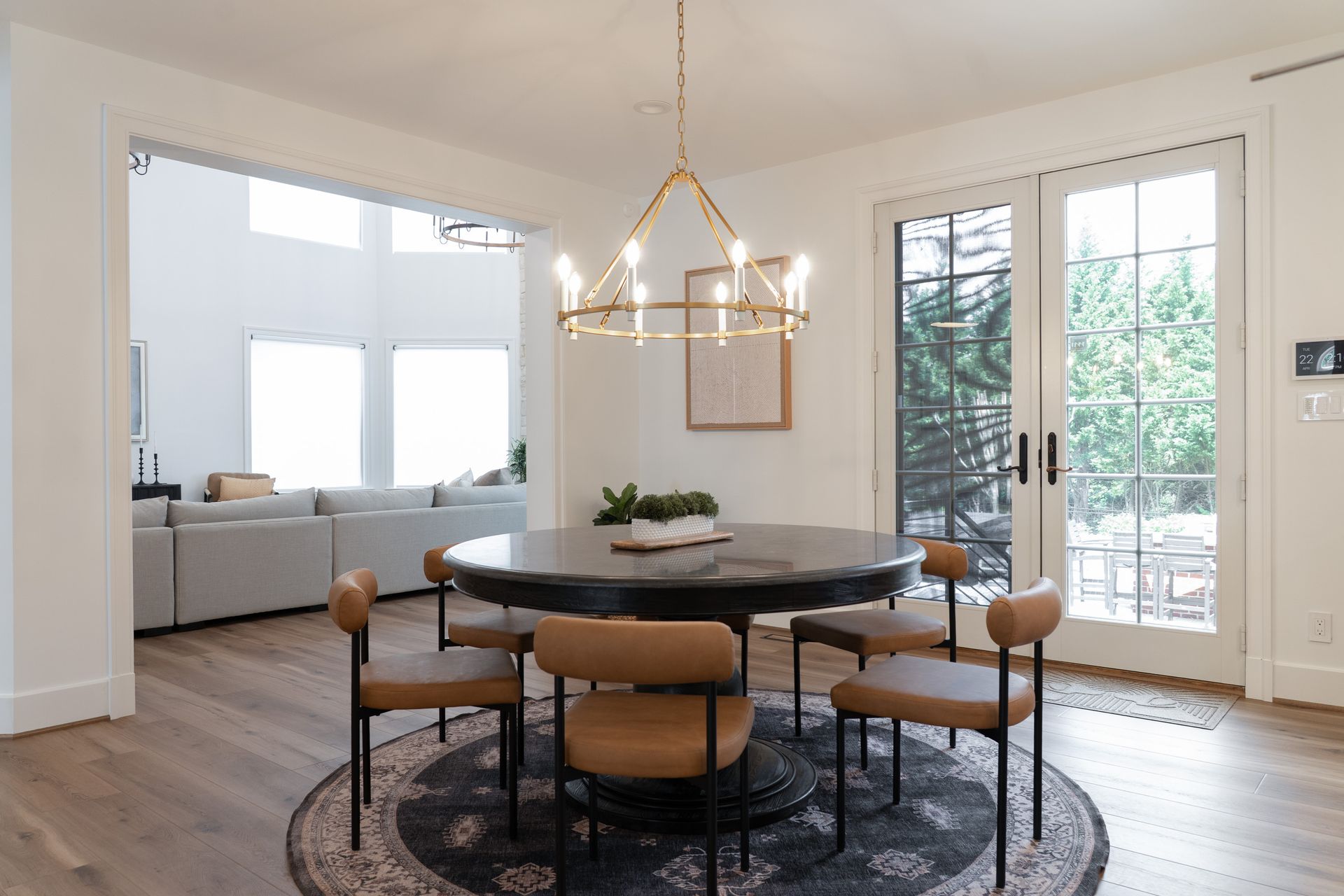 A dining room with a round table and chairs and a chandelier.