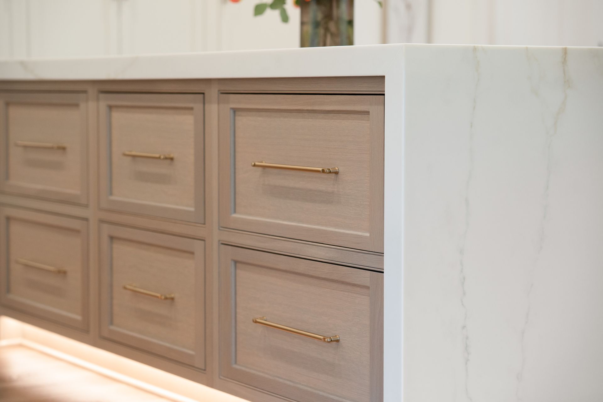 A kitchen with a lot of drawers and a white counter top.