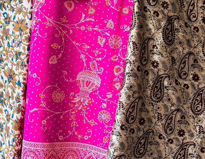 Tres telas colgantes: una blanca con estampado floral