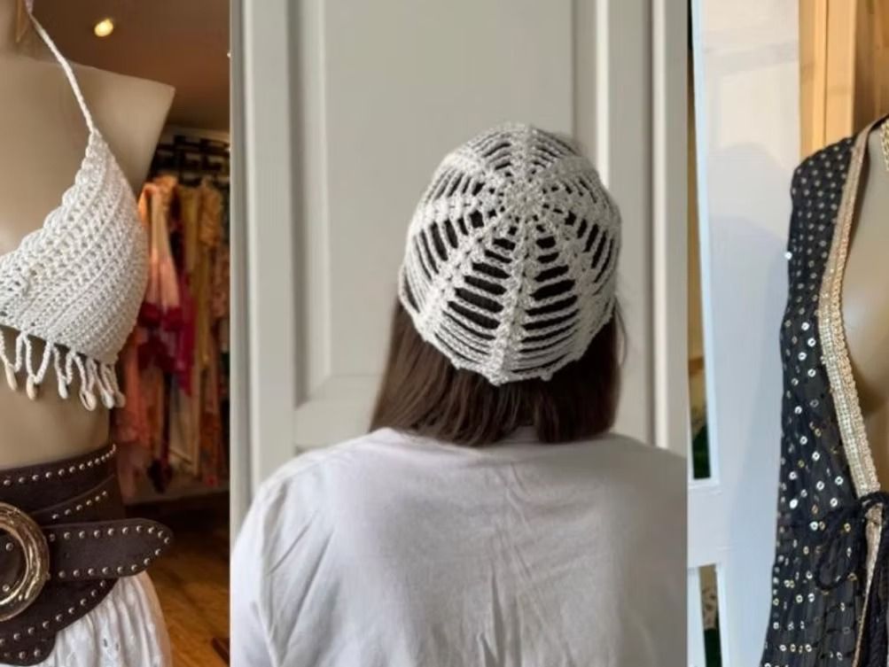 Persona con blusa blanca y gorro de ganchillo vista de espaldas en un probador de espejos de una boutique.