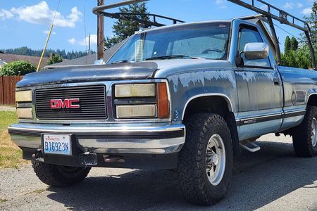 a gmc truck is parked on the side of the road