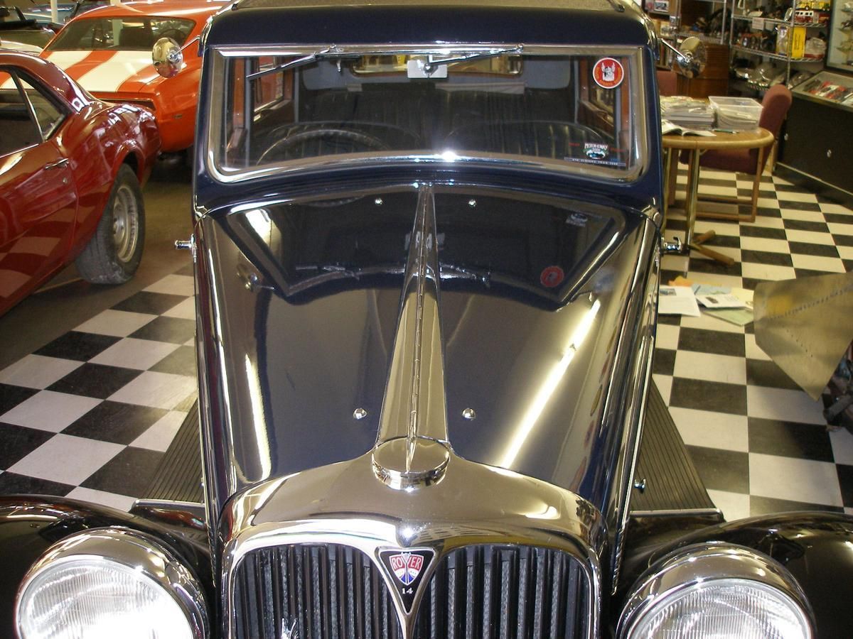 A black car is parked in a garage with a checkered floor