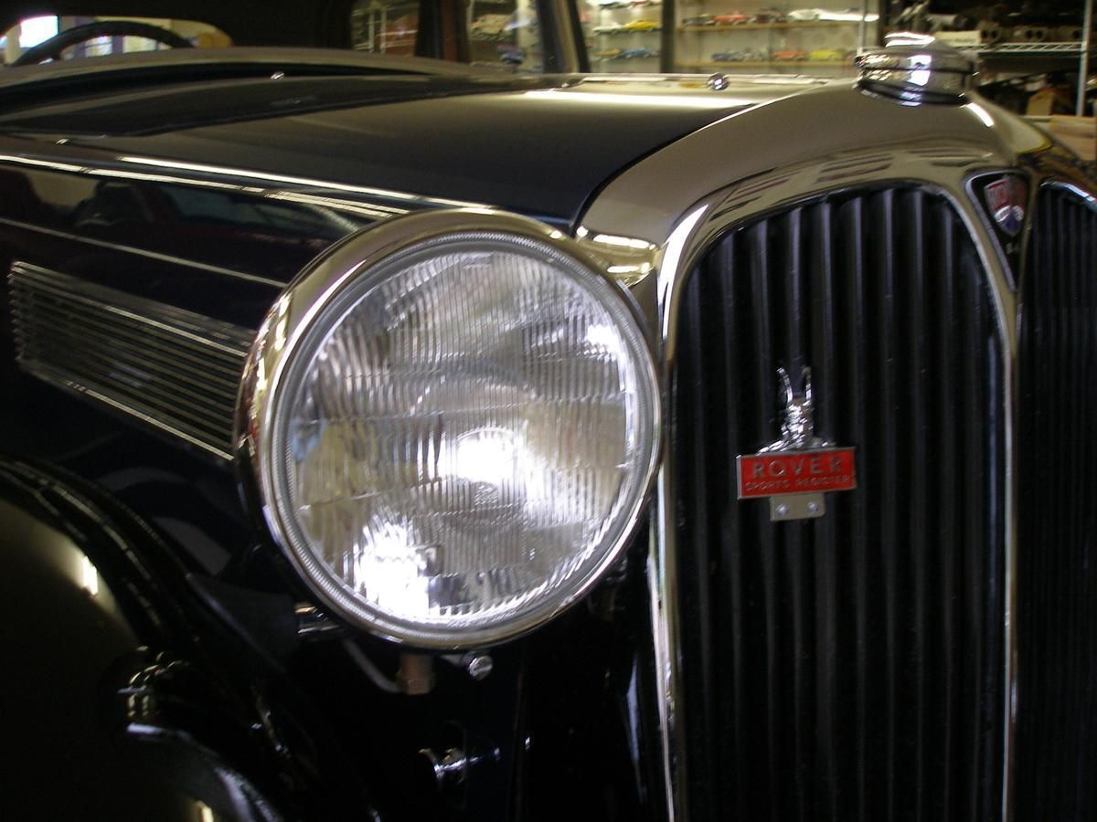 A close up of a car 's headlight and grille