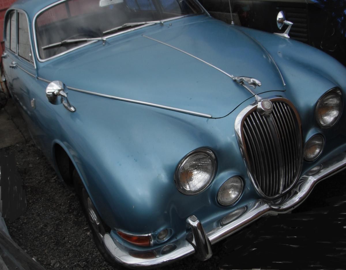 A blue jaguar car is parked in a parking lot