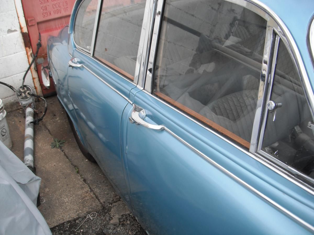 A blue car is parked in front of a garage door