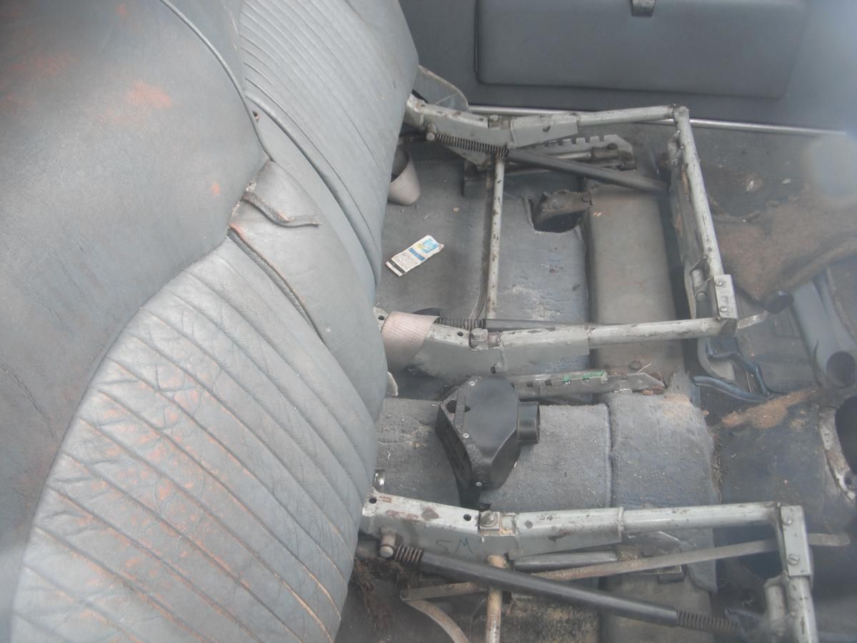 The back seat of a car with a seat frame missing