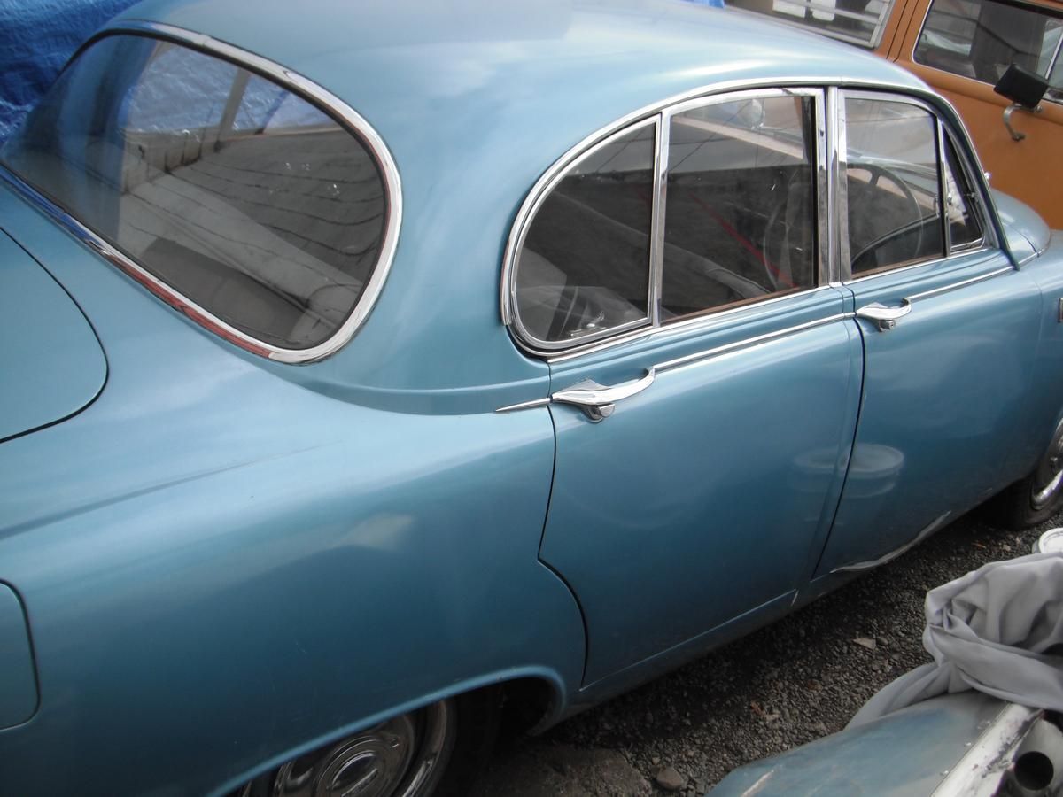A blue car is parked next to another car